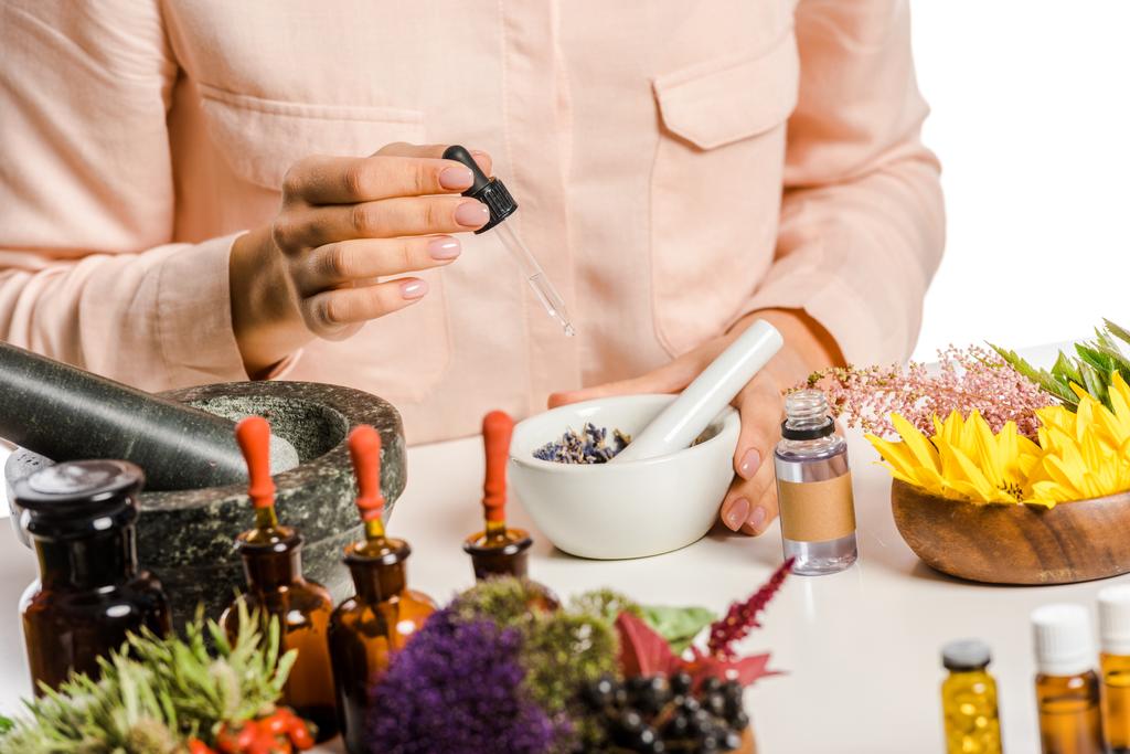 cropped image of woman adding essential oil to natural medicines isolated on white - Photo, Image