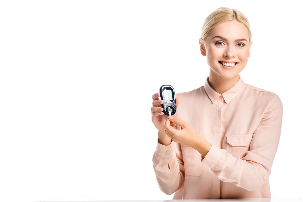 усміхнена жінка кладе смужку в глюкометр ізольовано на білому, концепція діабету
 - Фото, зображення