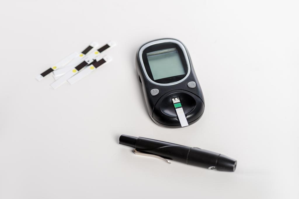 lékařské glukometr a proužky izolované na bílém - Fotografie, Obrázek