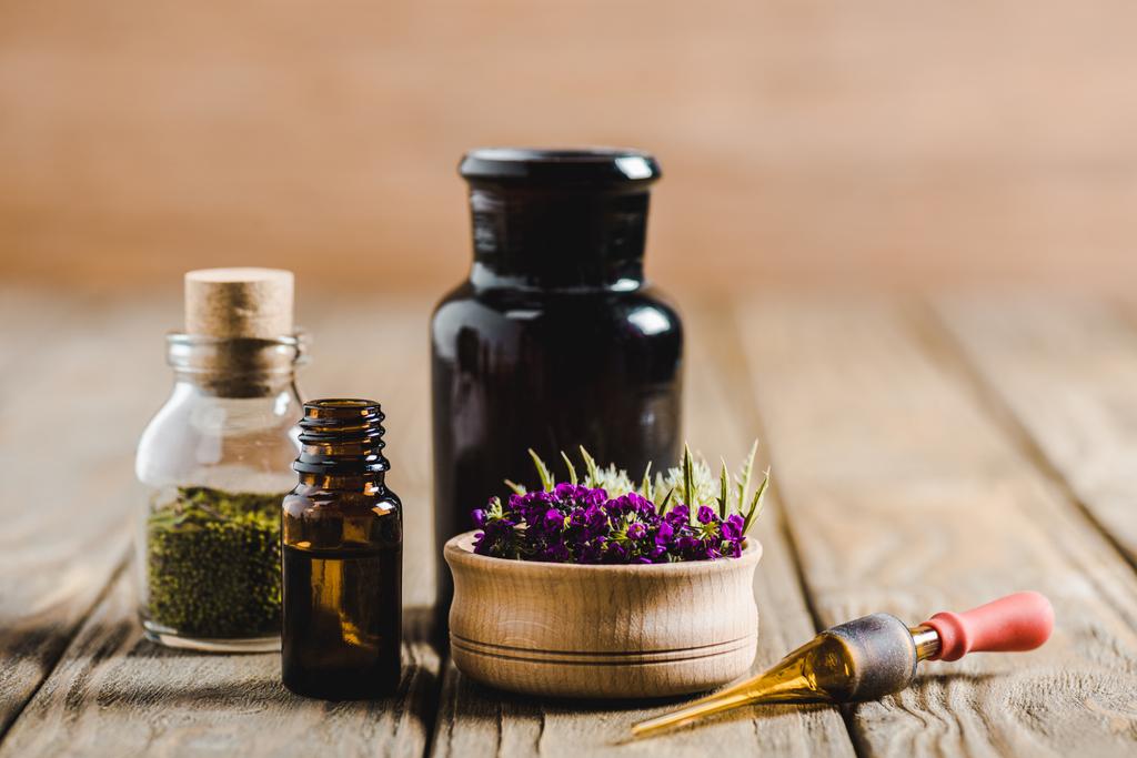 bottiglie di vetro di oli essenziali e fiori su tavolo in legno, concetto di medicina alternativa
 - Foto, immagini