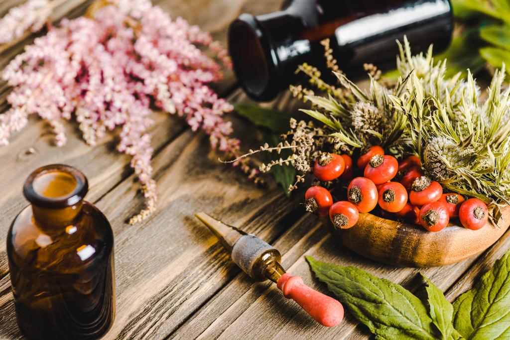 frascos de vidro e flores em mesa de madeira, conceito de medicina homeopatia alternativa
 - Foto, Imagem