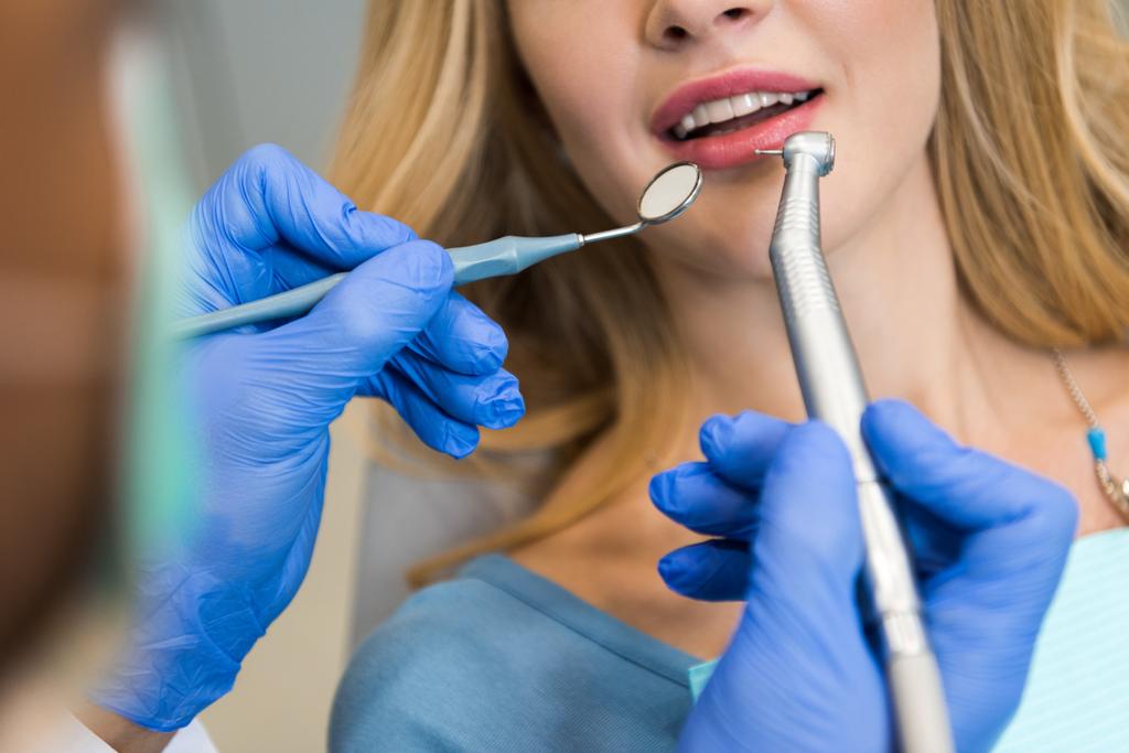 rajattu laukaus hammaslääkäri tutkii hampaita naispuolinen asiakas
 - Valokuva, kuva