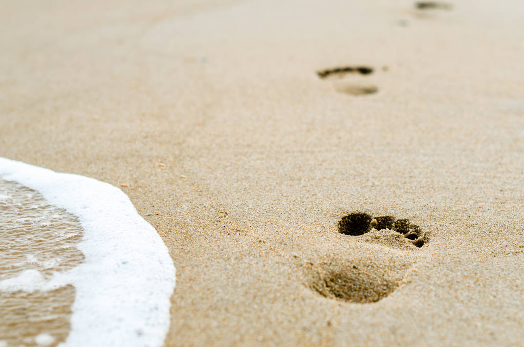 ślady stóp na piasku na plaży w pobliżu surf - Zdjęcie, obraz