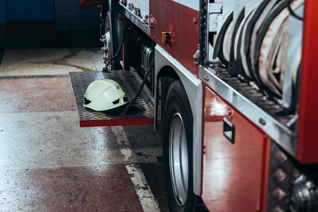 Blick aus nächster Nähe auf Schutzhelm auf Feuerwehrauto am Feuerwehrhaus - Foto, Bild
