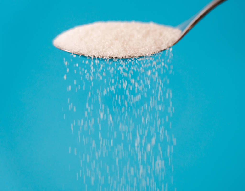 Сахар наливают из ложки в поток, изолированный на синем фоне в слишком много сахара сладкая зависимость диабет болезнь нездоровой пищи концепции
. - Фото, изображение