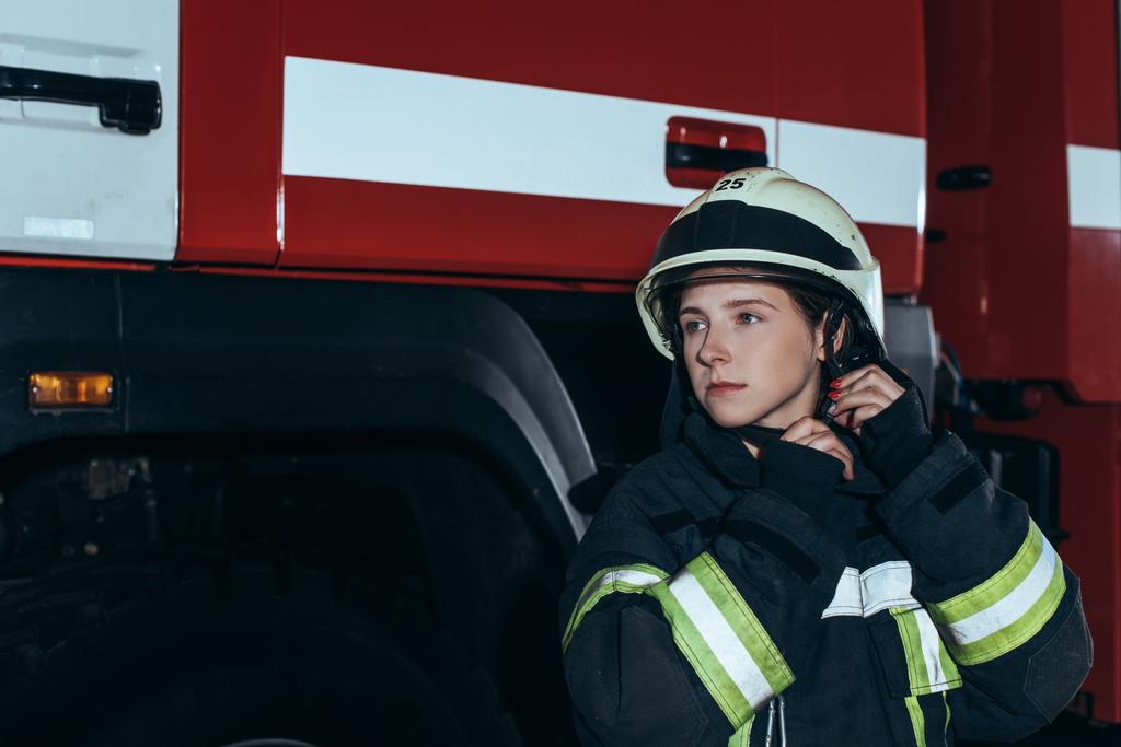retrato de bombero femenino en casco de control uniforme en la estación de bomberos
 - Foto, Imagen