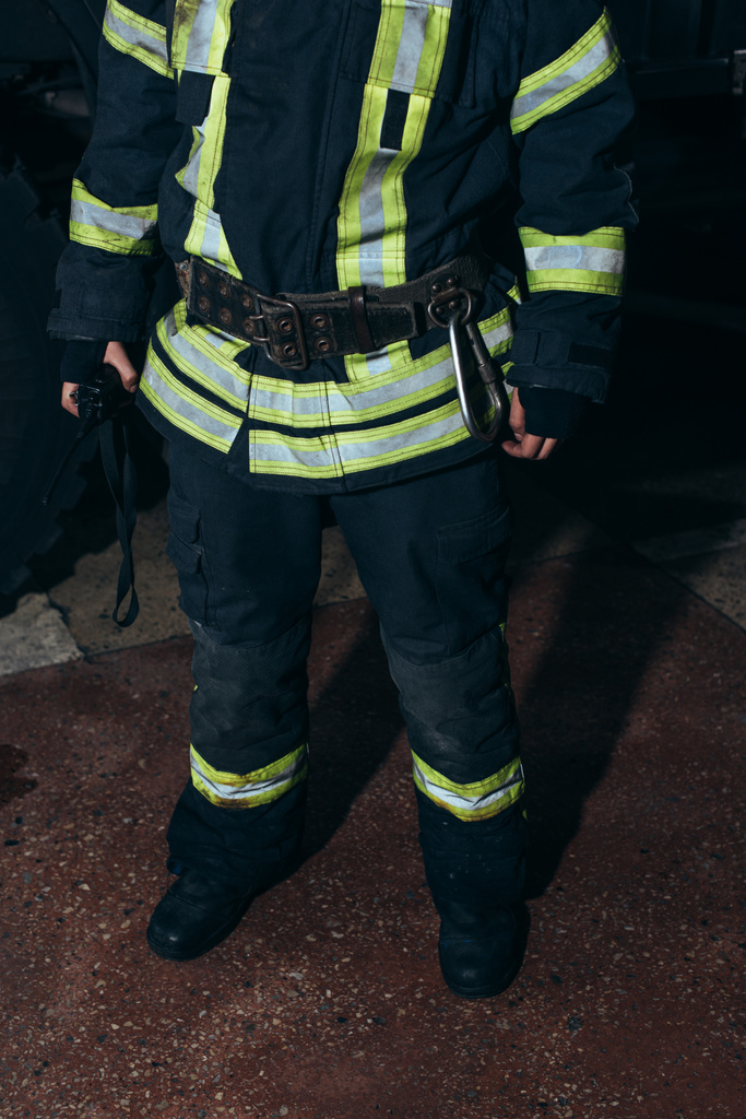 Teilansicht eines Feuerwehrmannes mit Mobilfunk bei der Feuerwehr - Foto, Bild