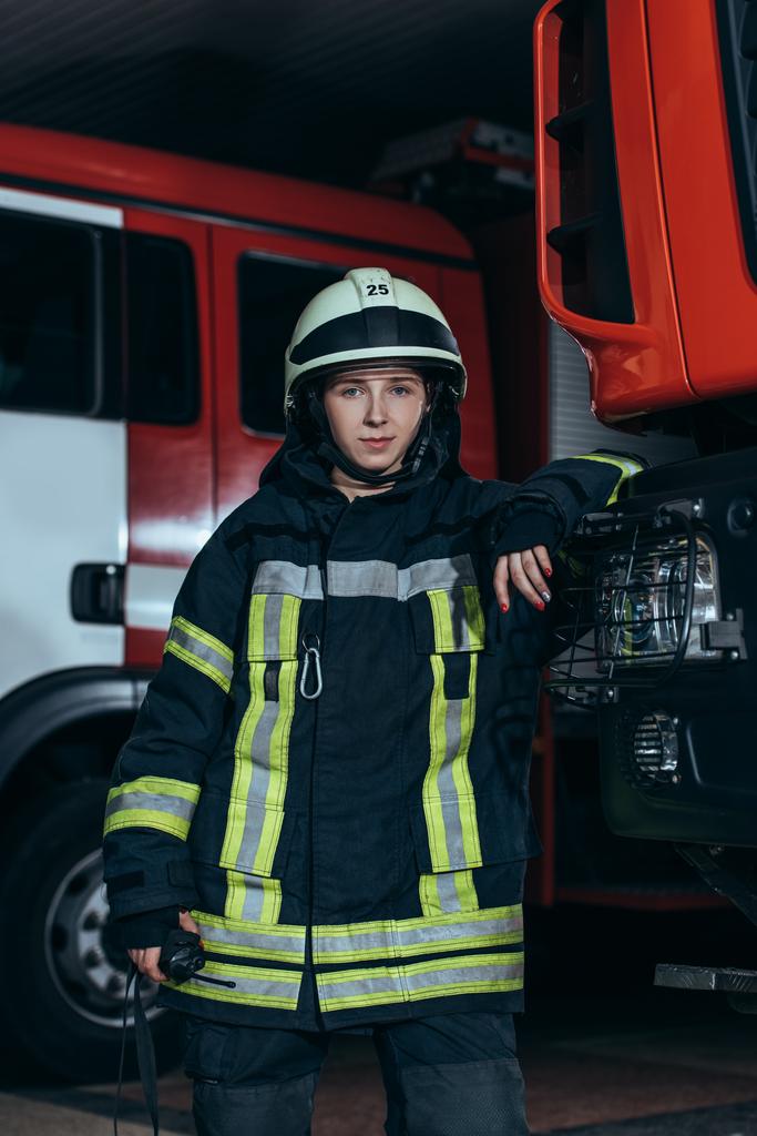 πορτρέτο της γυναικείας πυροσβέστης σε προστατευτική στολή με φορητό ραδιόφωνο στην πυροσβεστική υπηρεσία - Φωτογραφία, εικόνα