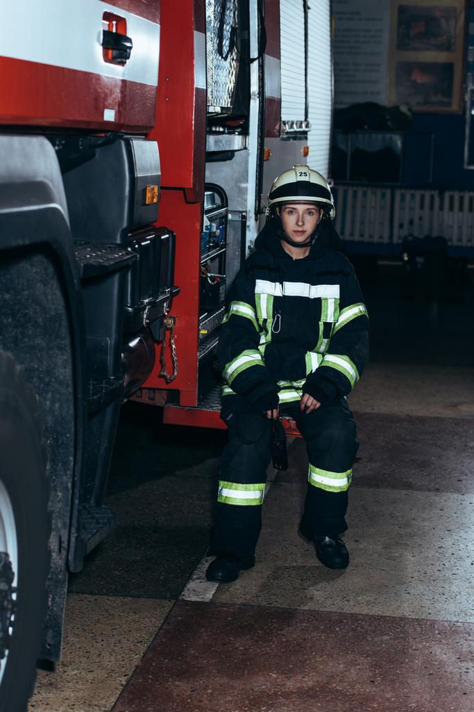 női tűzoltó védő egységes, hordozható rádió-ül a teherautó, tűzoltóság - Fotó, kép