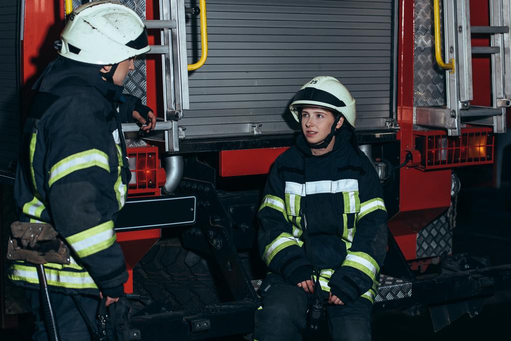pompiers en uniforme ignifuge et casques ayant une conversation à la caserne de pompiers
 - Photo, image