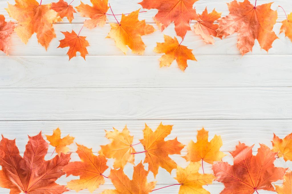 verhoogde weergave van Oranje herfst esdoorn bladeren op houten oppervlak - Foto, afbeelding