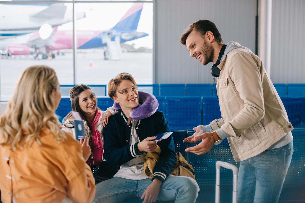 giovani sorridenti che controllano i documenti in attesa del volo nel terminal dell'aeroporto
 - Foto, immagini