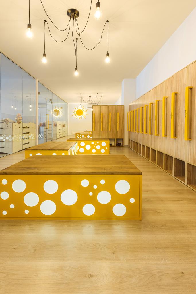 wooden lockers, benches and mirror in illuminated kindergarten cloakroom   - Photo, Image