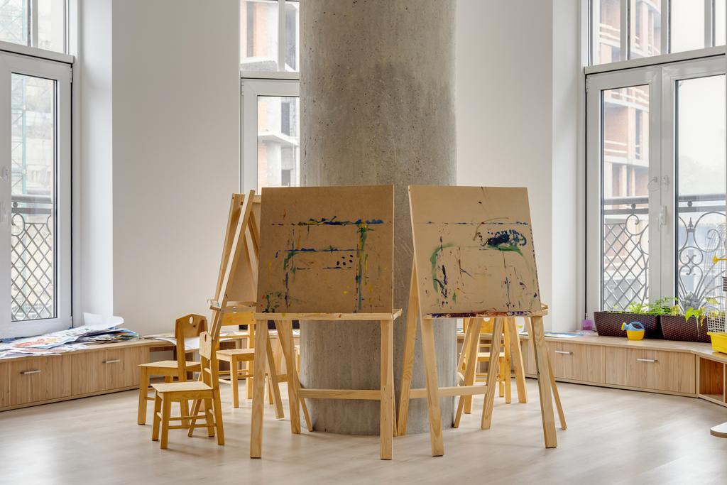 easels and wooden chairs in classroom at modern kindergarten - Photo, Image