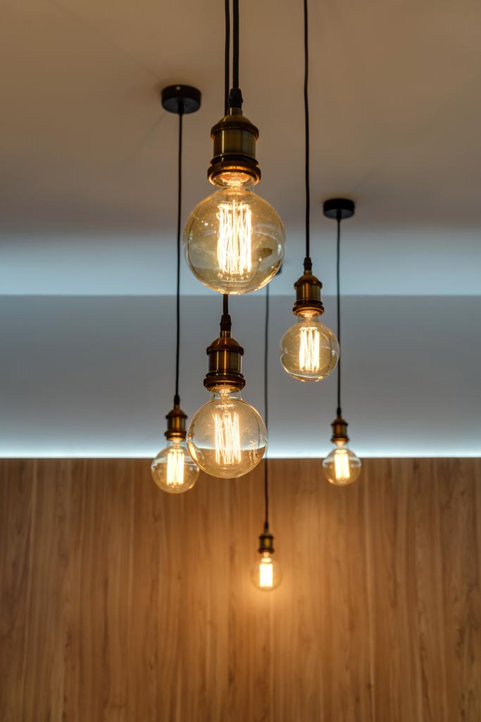 vue rapprochée des ampoules lumineuses suspendues dans une pièce vide
 - Photo, image
