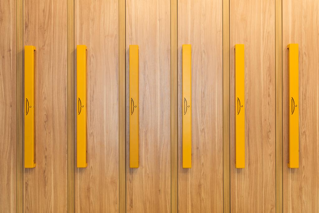 Προβολή πλήρους καρέ ξύλινα ντουλάπια με κίτρινες λαβές στο νηπιαγωγείο  - Φωτογραφία, εικόνα