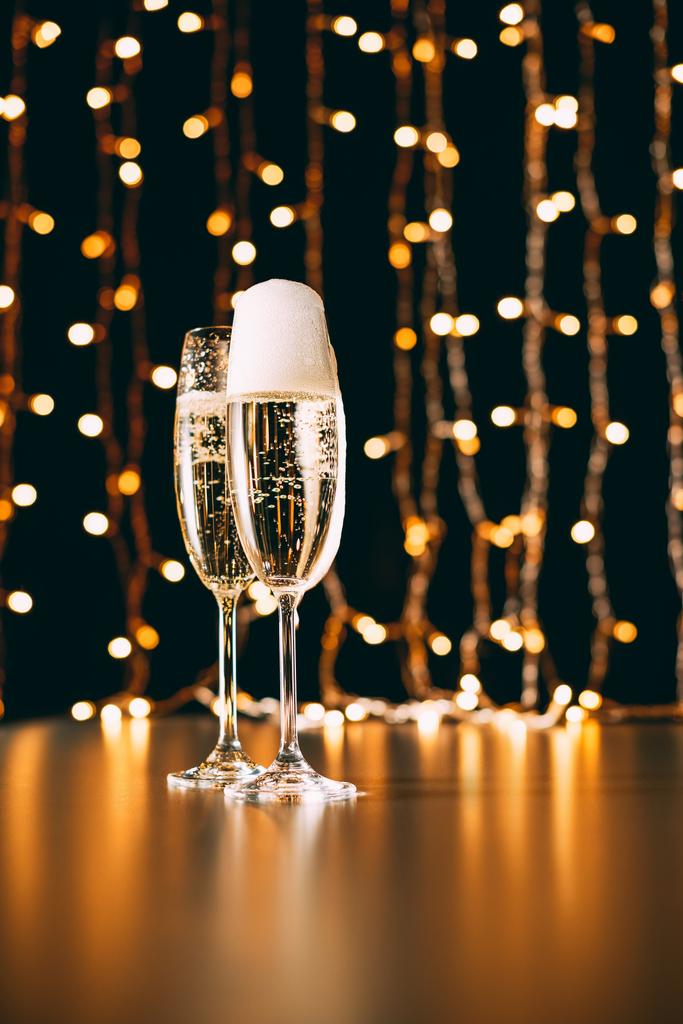 glazen champagne op garland lichte achtergrond, Kerstmis concept - Foto, afbeelding
