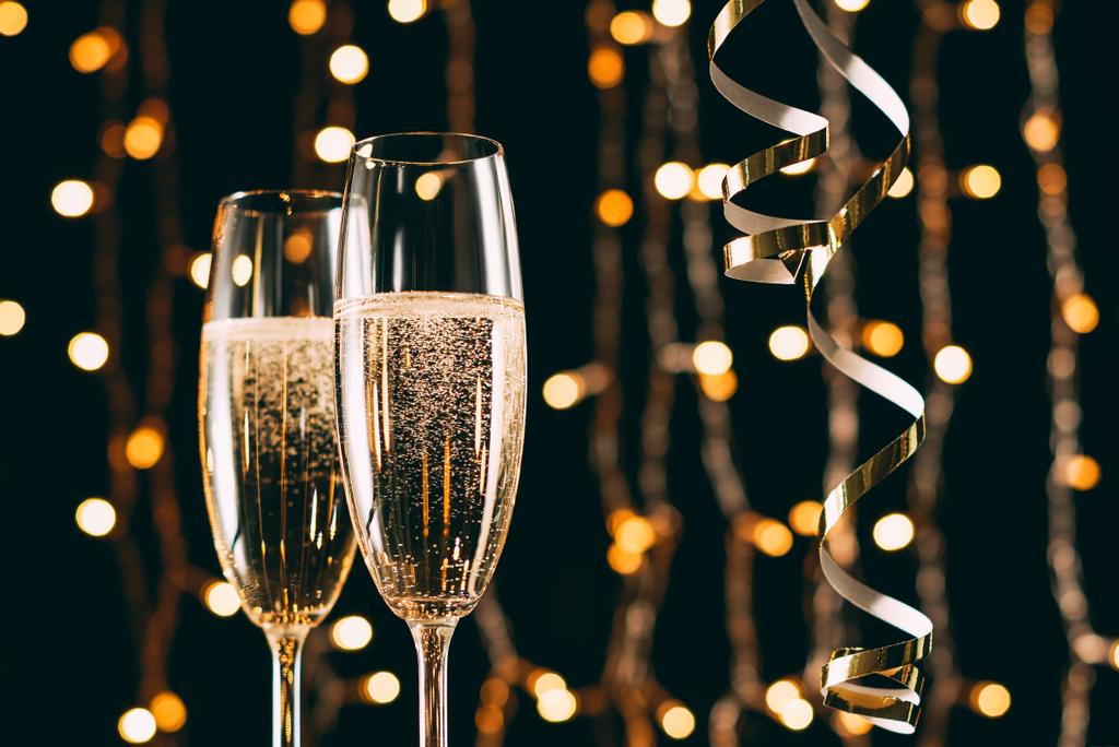 champán en copas y cintas sobre fondo claro guirnalda, concepto de Navidad
 - Foto, imagen