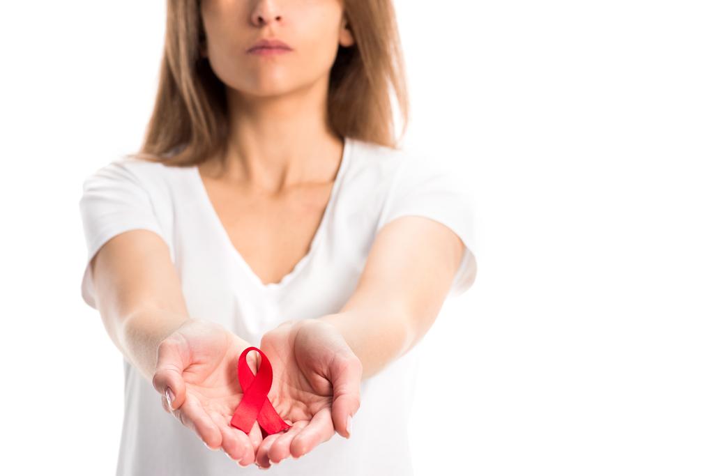 imagen recortada de la mujer sosteniendo cinta roja en las manos aisladas en blanco, concepto del día del sida mundial
 - Foto, imagen