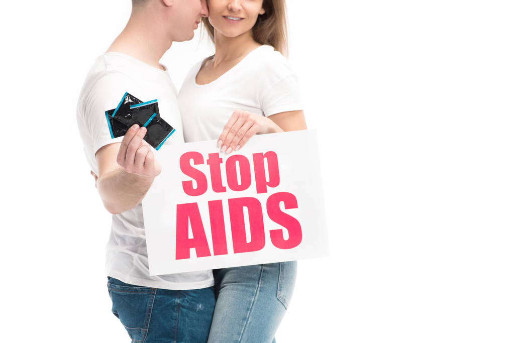 Erkek arkadaşım prezervatif ve kız arkadaşı holding kartı üzerinde beyaz izole stop AIDS metinle gösterilen kırpılmış görüntü - Fotoğraf, Görsel