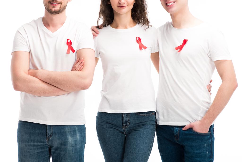 abgeschnittenes Bild von Männern und Frauen mit roten Bändern, die sich isoliert auf weißem Grund umarmen, Konzept zum Welthilfetag - Foto, Bild