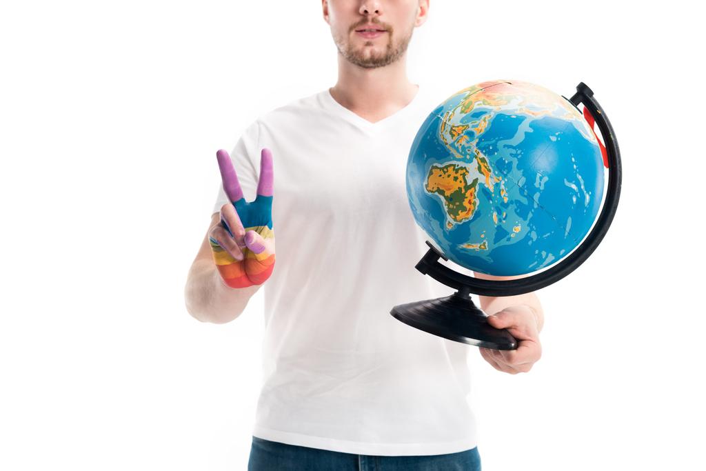 cropped image of man holding globe and showing peace sign with hand painted in rainbow isolated on white, world aids day concept - Photo, Image