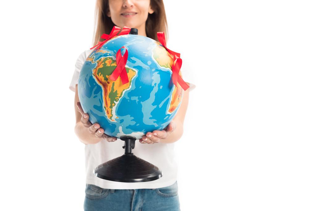 abgeschnittenes Bild einer Frau, die Globus mit roten Bändern auf weißem Hintergrund hält, Konzept zum Welthilfetag - Foto, Bild