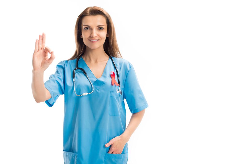 atractivo médico con cinta roja mostrando gesto bien aislado en blanco, el mundo SIDA concepto del día
 - Foto, imagen