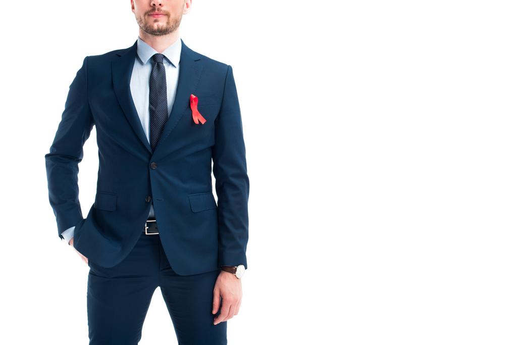 cropped image of businessman standing with red ribbon on suit isolated on white, world aids day concept - Photo, Image