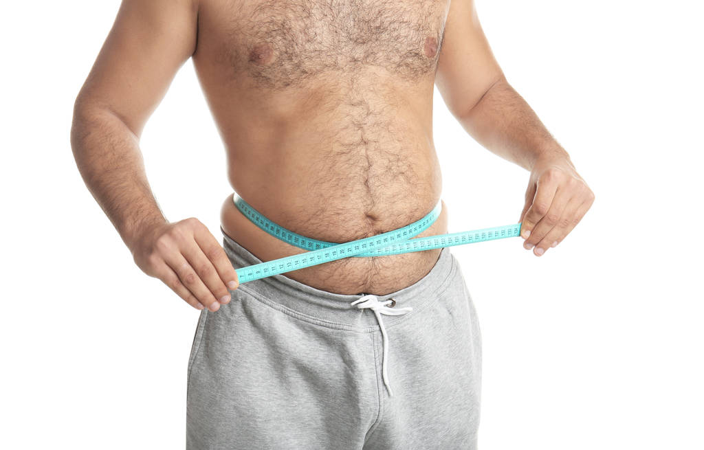 Hombre con sobrepeso con cinta métrica sobre fondo blanco, primer plano
 - Foto, imagen