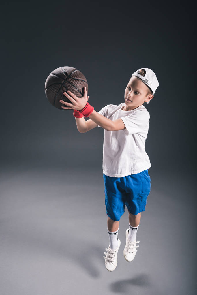 ragazzo elegante che gioca a basket su sfondo grigio
 - Foto, immagini