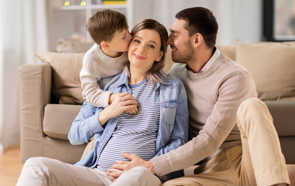 glückliche Familie mit schwangerer Mutter zu Hause - Foto, Bild
