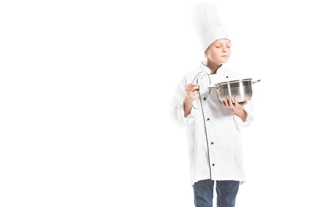 portrait of pre-adolescent boy in chef uniform with saucepan isolated on white - Photo, Image