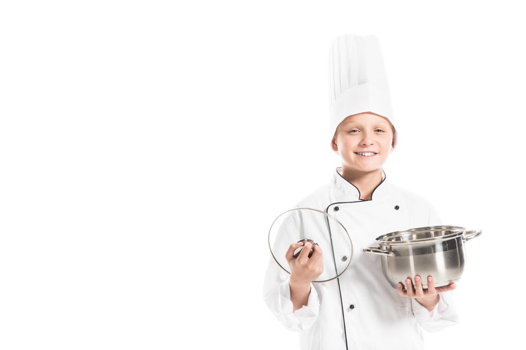 portrait of smiling boy in chef uniform with saucepan isolated on white - Photo, Image