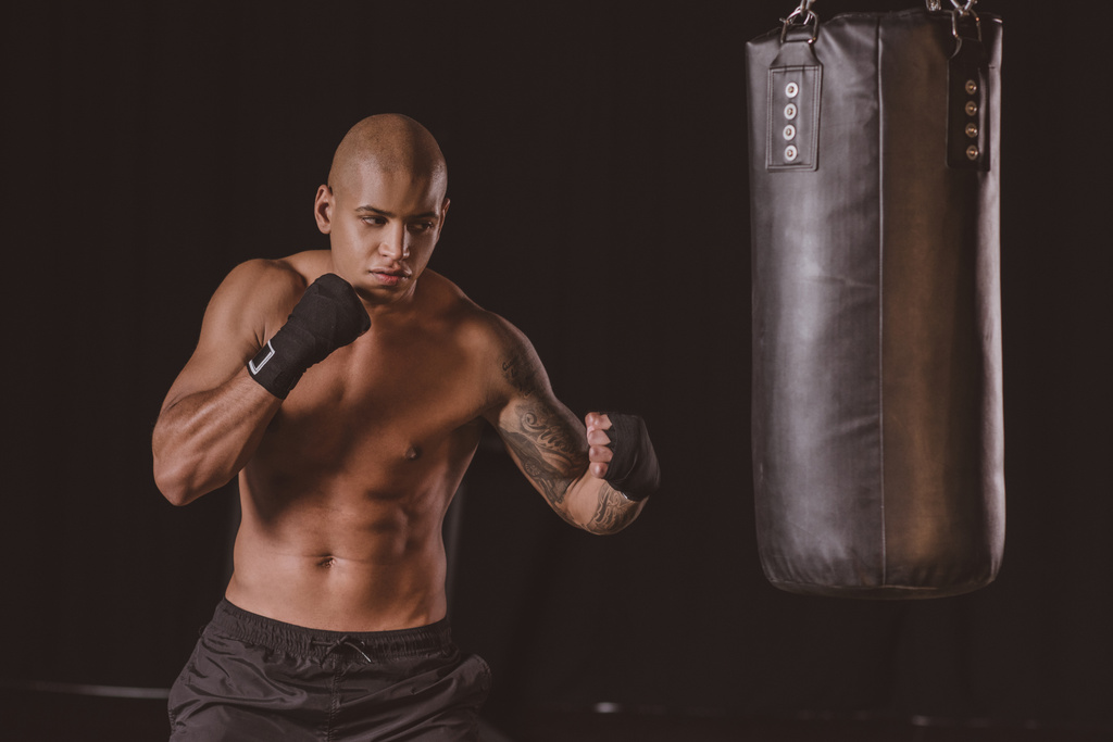ジムでサンドバッグ トレーニング筋肉のアフリカ系アメリカ人男性のボクサー ロイヤリティフリー写真 画像素材