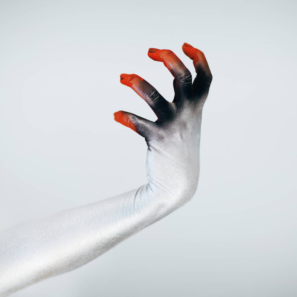 Gruselige Halloween-Monster-Hand mit weißer, roter und schwarzer Schminke vor weißem Hintergrund - Foto, Bild