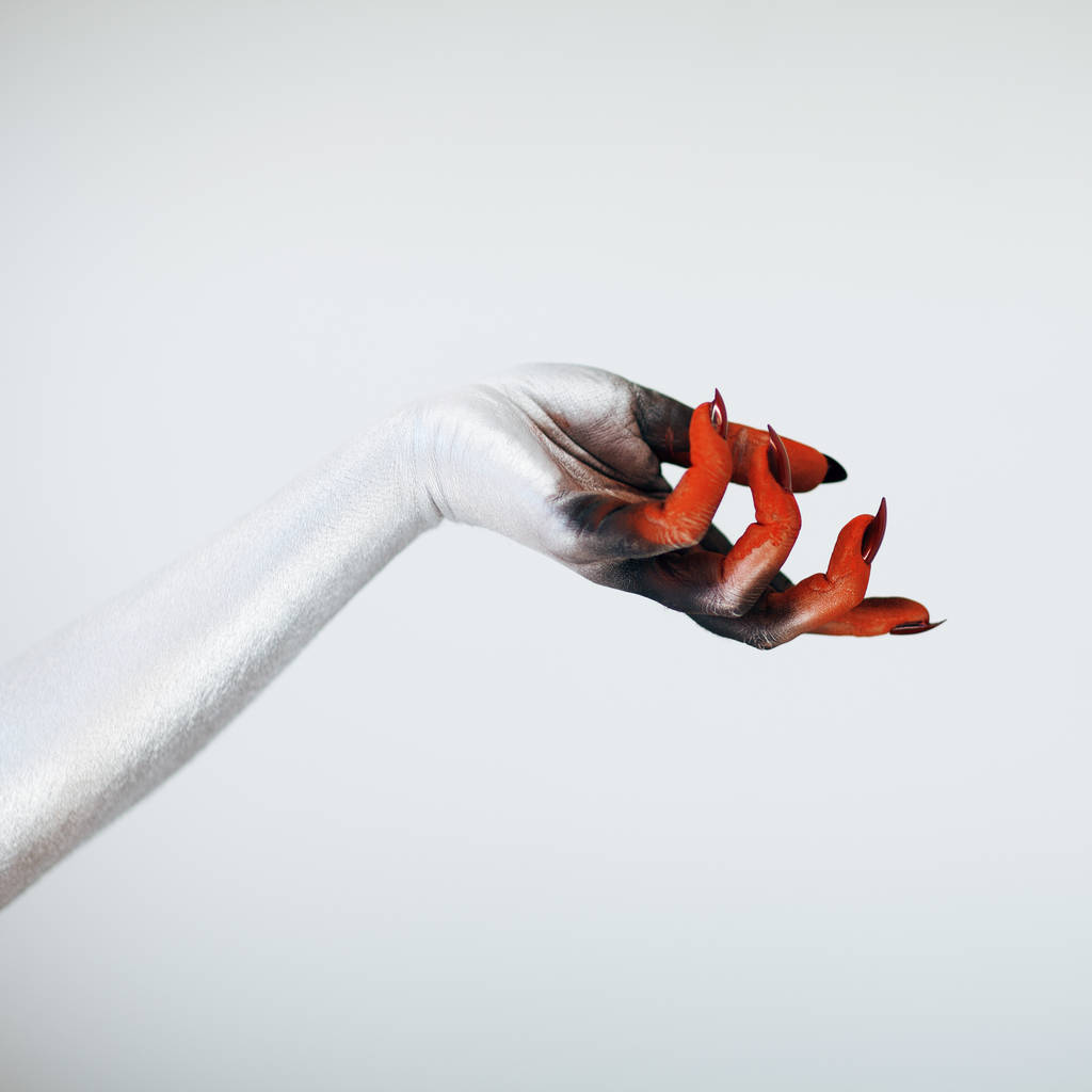 Espeluznante mano bruja monstruo de Halloween con blanco, rojo y negro maquillaje y largas uñas espeluznantes en frente de fondo blanco
  - Foto, imagen