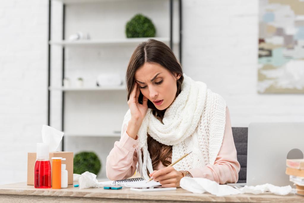 sick young businesswoman trying to work while suffering from headache at workplace - Photo, Image