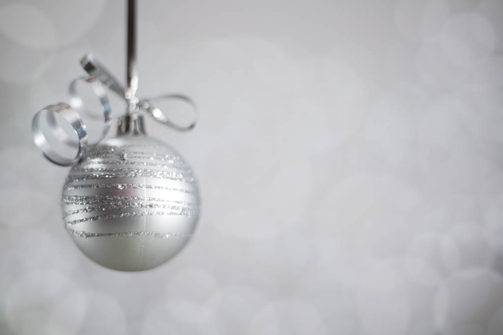 Silber Weihnachten Neujahrsball mit lockigen Luftschlange Band Bogen über glitzernden Bokeh Lichter Hintergrund mit Kopierraum für Text - Foto, Bild