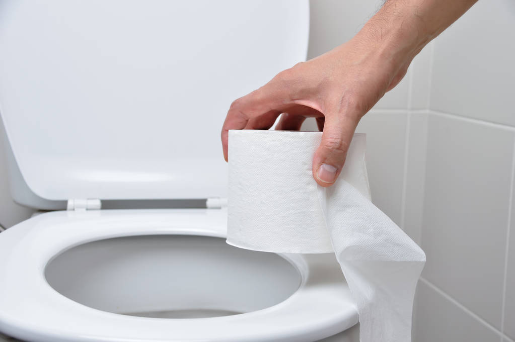 zbliżenie ręki człowieka za pomocą papieru toaletowego - Zdjęcie, obraz