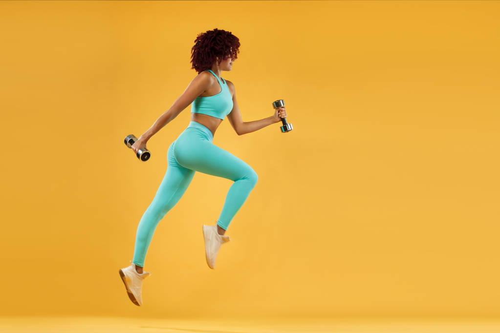 Сильний атлетичний, жіночий бігун на чорному фоні в міцному вбранні
. - Фото, зображення
