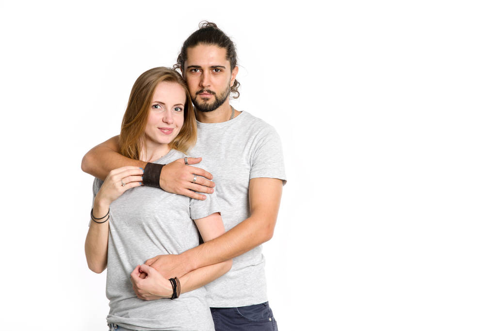 白い背景の上の幸せなカップルの肖像画。カップル男と女を抱き締めるとカメラ目線. - 写真・画像