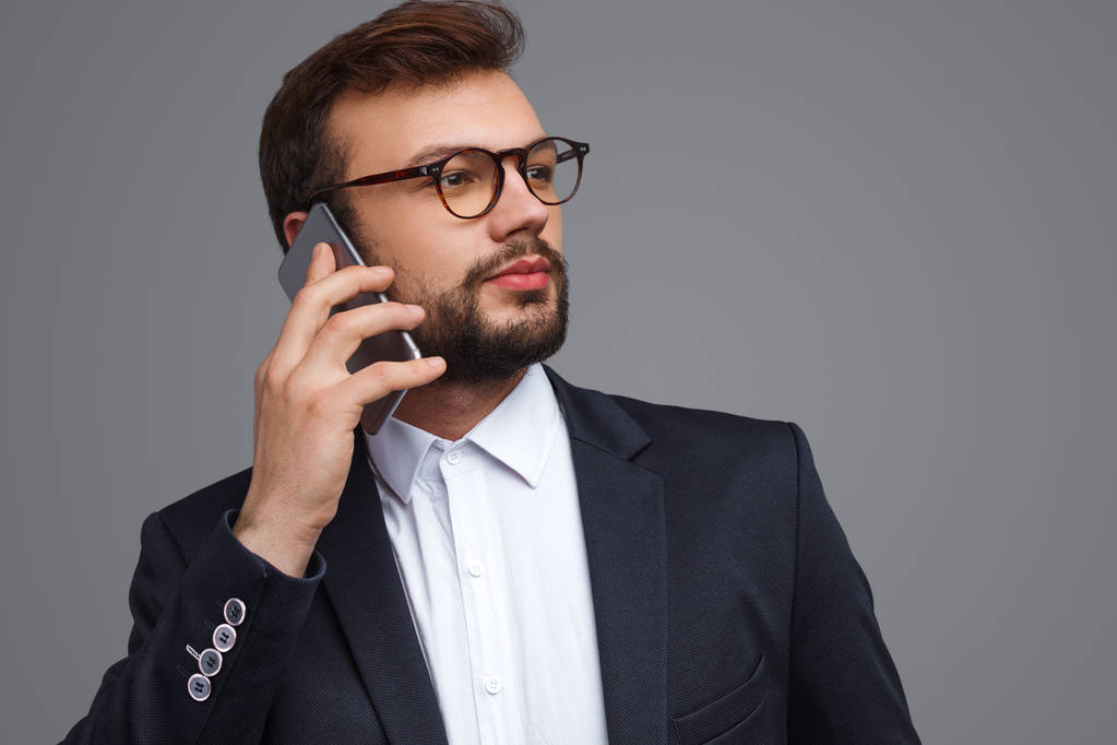 Businessman speaking on phone and looking away - Photo, Image