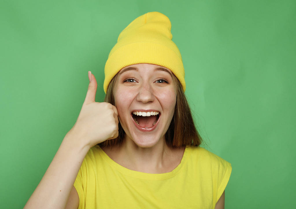 elämäntapa, tunteet ja ihmiset käsite: Onnellinen nainen yllään keltaisia vaatteita antaa peukalo ylös
 - Valokuva, kuva