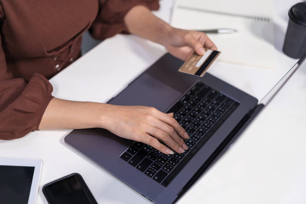 handen houden van een credit card en het gebruik van laptop voor online winkelen - Foto, afbeelding