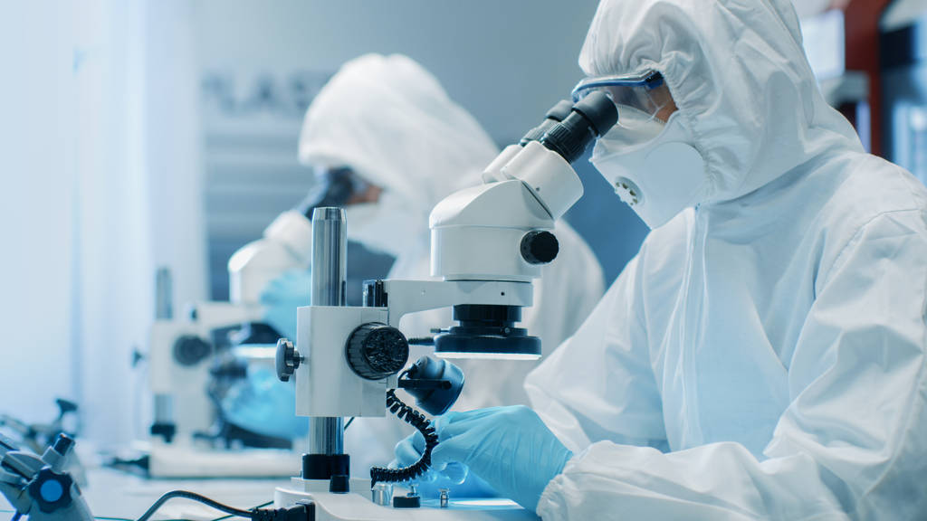 Dva inženýři / vědci / technici v oblecích sterilní čisté provozy používají mikroskopy pro přizpůsobení komponenty a výzkum. Pracují v elektronické součástky továrny vyrábějící. - Fotografie, Obrázek