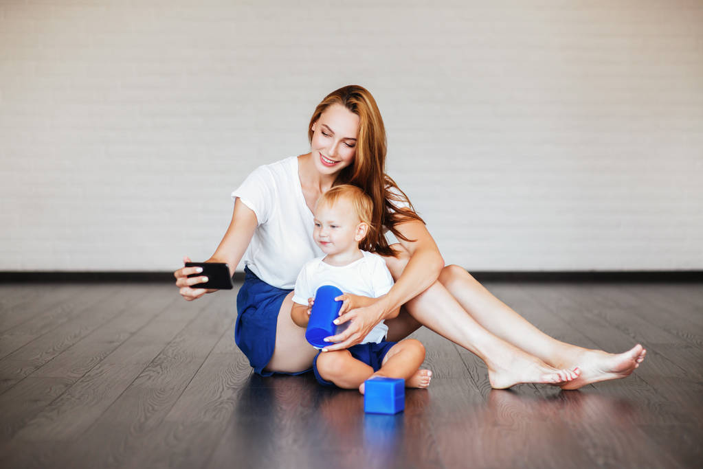 Mãe feliz com filho e smartphone, auto atirar
 - Foto, Imagem