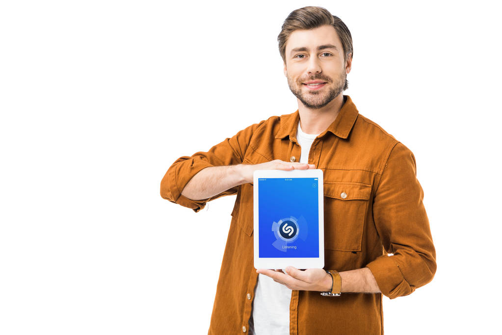Junger glücklicher Mann zeigt digitales Tablet mit Shazam auf Bildschirm isoliert auf Weiß - Foto, Bild