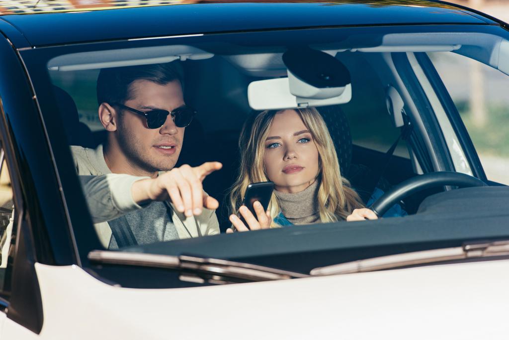 człowiek z smartphone wskazujące kierunek do dziewczyna w samochodzie - Zdjęcie, obraz