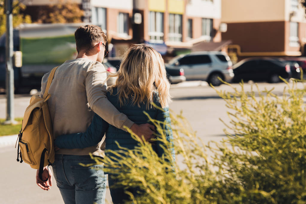 visão traseira do casal abraçando enquanto caminhava na rua na nova cidade
 - Foto, Imagem